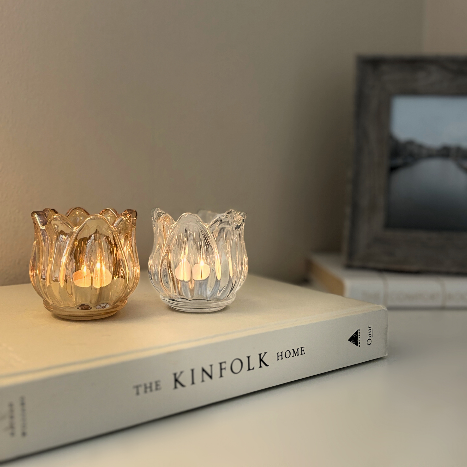 Two glass candle holders on a book
